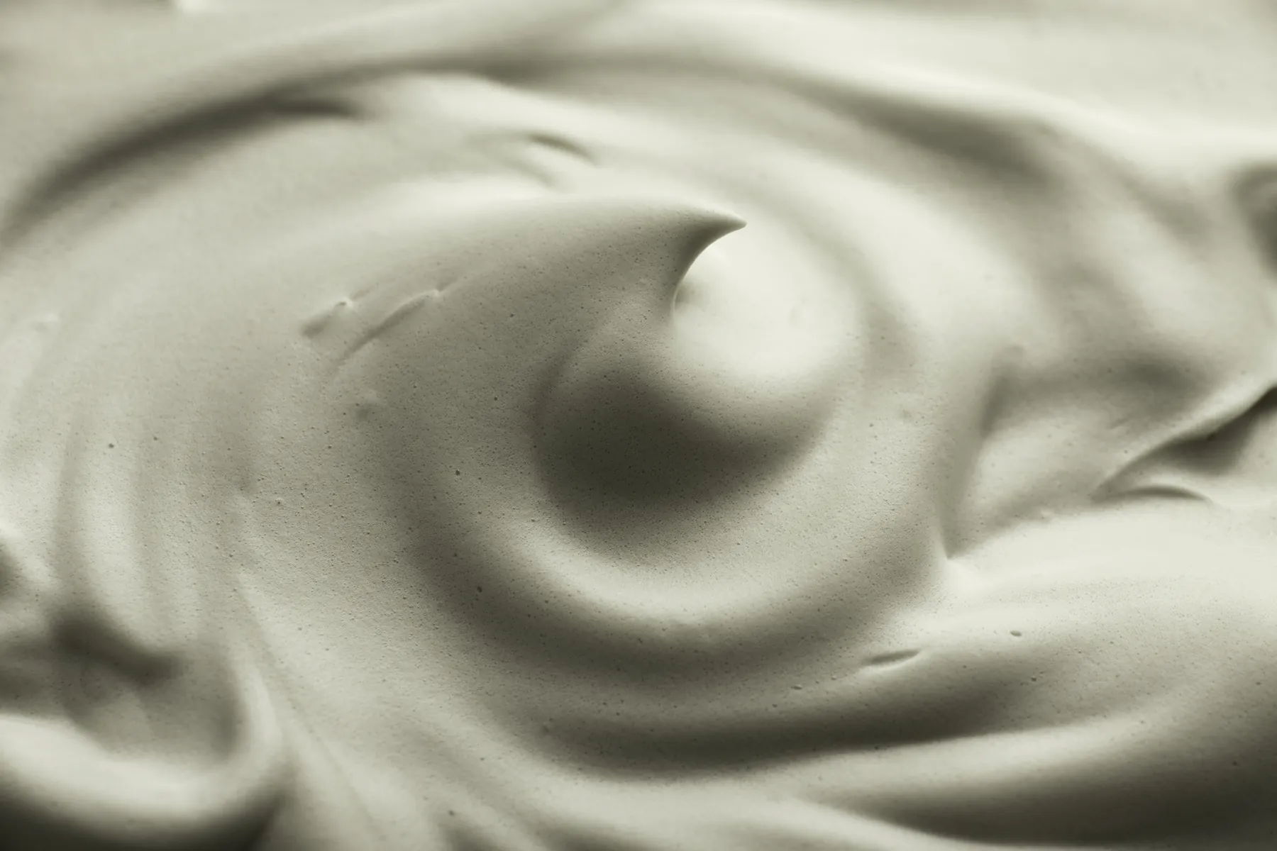Close-up of a swirl of sage-green cream